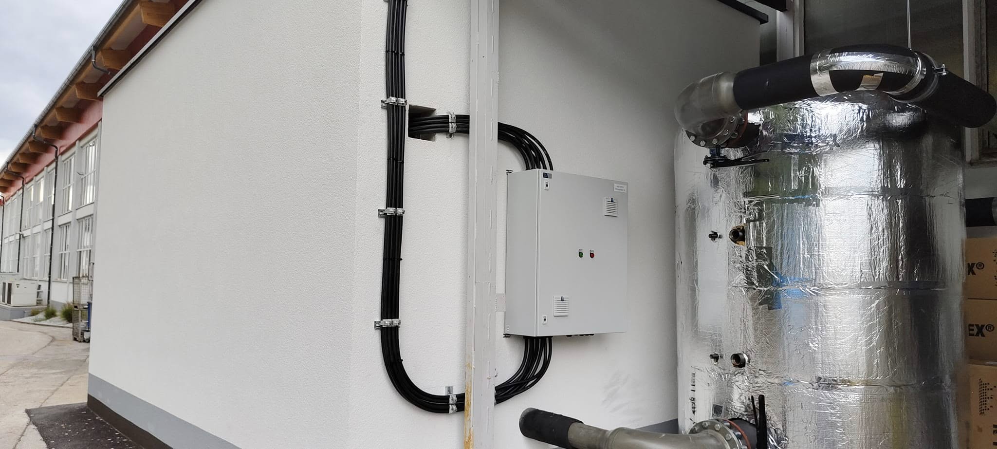 Elektroinstallation mit verlegten Kabeln und Schaltkasten an einer Gebäudewand